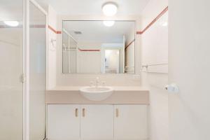 un bagno bianco con lavandino e specchio di Seacrest Unit 3 Moffat Beach QLD a Caloundra