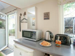 um balcão de cozinha com um micro-ondas e um prato de pão em Aremo Garden House em Torquay