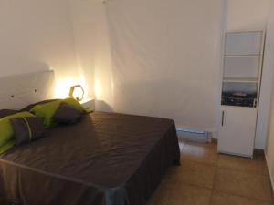 1 dormitorio con 1 cama y nevera pequeña en Alameda en Paraná