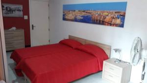 Room in Apartment - very bright well kept apartment في مارساسكالا: غرفة نوم بسرير احمر وخزانة بها مصباح