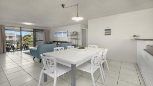 een keuken en eetkamer met een witte tafel en stoelen bij Sealanes Unit 8 Kings Beach QLD in Caloundra