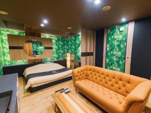 ein Wohnzimmer mit Sofa und Bett in der Unterkunft GLAMROSE -Adult Only Motel- in Gotemba