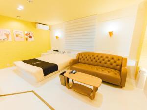 a hotel room with a bed and a couch at GLAMROSE -Adult Only- in Gotemba