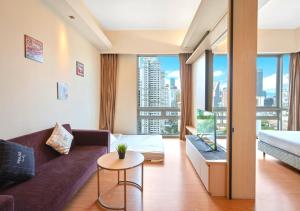 a living room with a couch and a large window at Greystone Swiss Garden Residence in Kuala Lumpur