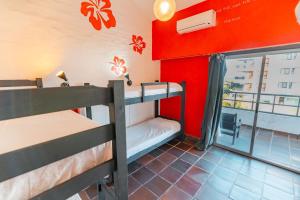 two bunk beds in a room with a red wall at Hostel 32 in Punta del Este