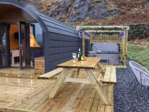 a wooden deck with a picnic table and a grill at The Shearer - Crossgate Luxury Glamping in Penrith