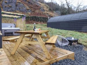 a picnic table with a bottle of wine on a deck at Lovies Place - Crossgate Luxury Glamping in Penrith