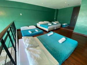 two beds in a room with green walls at Cebu City Huge Lofts by P&J in Cebu City