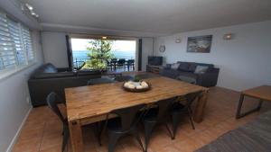 uma sala de estar com uma mesa de madeira e um sofá em Wickham Point Unit 4 Kings Beach QLD em Caloundra