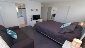 um quarto com uma cama e um sofá em Wickham Point Unit 4 Kings Beach QLD em Caloundra