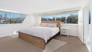 una camera da letto con un letto e due finestre di Wickham Point Unit 5 Kings Beach QLD a Caloundra