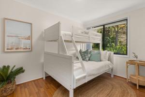 a white bunk bed in a white room with a couch at A Pets Paradise by Experience Jervis Bay in Vincentia