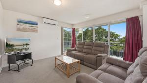 Windbourne unit 4 Golden Beach QLD في Golden Beach: غرفة معيشة بها أريكة وتلفزيون