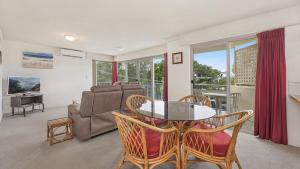 Windbourne unit 4 Golden Beach QLD في Golden Beach: غرفة معيشة مع طاولة وكراسي وأريكة