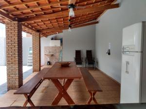 uma mesa de madeira e banco numa sala de estar em Recanto Fernandes & Melo em Olímpia