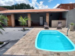 a swimming pool in a yard with a house at Recanto Fernandes & Melo in Olímpia