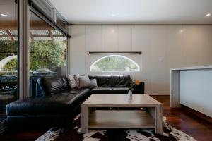 a living room with a black leather couch and a table at Losari Retreat in Margaret River Town