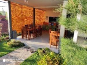 un patio con tavoli e sedie in giardino di Singgahan Bungalow by ecommerceloka a Nusa Penida