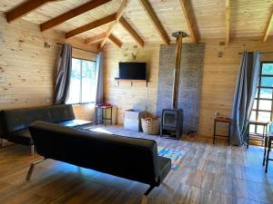 a living room with a couch and a fireplace at Cabaña Loncoche / Villarrica in Loncoche