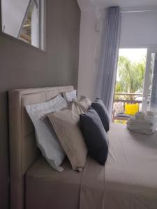 1 cama con almohadas y ventana en North Suíte, en Florianópolis