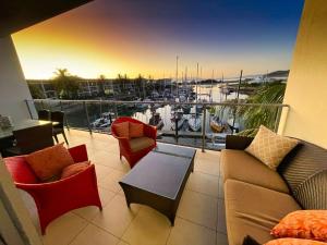 d'un balcon avec un canapé, des chaises et une table. dans l'établissement Blue on Blue Apartment 933, à Nelly Bay