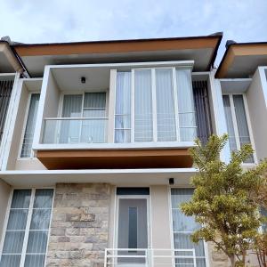 バトゥにあるVilla Beliciaの白窓と木のある家