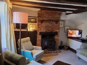 a living room with a fireplace and a tv at Monk House - Historic Foundation Invites guests in Petworth