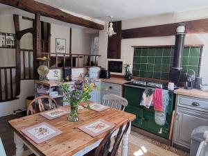 cocina con mesa de madera y horno verde en Monk House - Historic Foundation Invites guests en Petworth