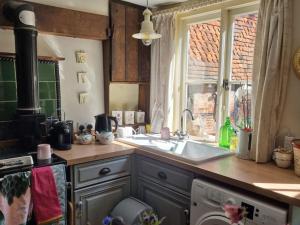 a kitchen with a sink and a washing machine at Monk House - Historic Foundation Invites guests in Petworth