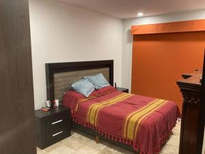 1 dormitorio con 1 cama con manta roja y amarilla en COZY 2Br 2Ba Apartment w/grill Terrace & Parking, en Ciudad de México