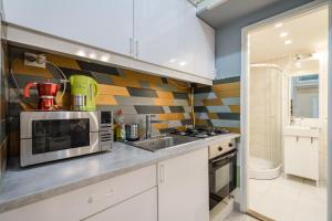 eine Küche mit Mikrowelle und Spüle in der Unterkunft Z44- Boutique Apartment, Best Location. By BQA in Budapest