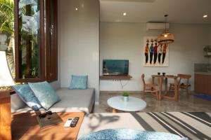 a living room with a couch and a table at Prema Uja Villas in Ubud