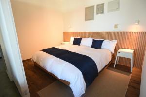 una camera da letto con un grande letto con cuscini bianchi e blu di FIRST STREET Okinawa Yomitan-son Oceans -SEVEN Hotels and Resorts- a Yomitan
