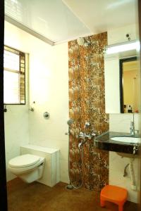 a bathroom with a toilet and a shower and a sink at Hotel Shreyas in Pune