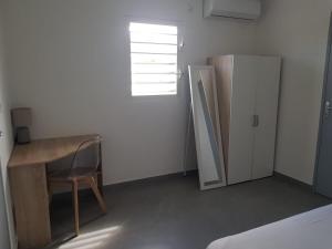 a small room with a desk and a refrigerator at Superbe appartement cosy neuf in Saint Martin