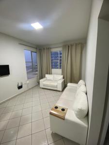 sala de estar con 2 sofás blancos y TV en Apartamento vista para o mar, en Balneário Camboriú