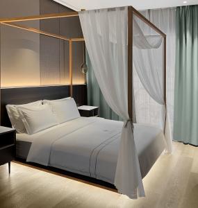 sypialnia z łóżkiem z baldachimem w obiekcie Looma Private Pool Villas w mieście Pantai Cenang