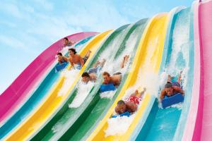 a group of children riding a water slide at a water park at Herodotos Studios in Keri