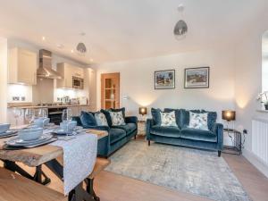 una sala de estar con 2 sofás azules y una mesa. en Forest Acorn en Brockenhurst
