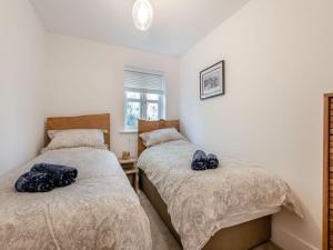 1 dormitorio con 2 camas y ventana en Forest Acorn en Brockenhurst