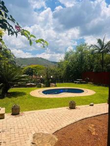 a garden with a swimming pool in the grass at Ka~Mo Gae in Louis Trichardt