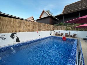 琅勃拉邦的住宿－Little Friendly Guest House and Swimming Pool，木制围栏旁的大型蓝色游泳池