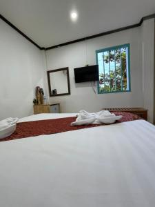 琅勃拉邦的住宿－Little Friendly Guest House and Swimming Pool，一间卧室设有两张白色的床和窗户