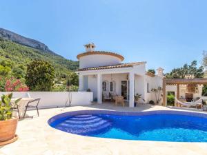 a villa with a swimming pool and a house at Scenic Villa, Costa Blanca in Denia