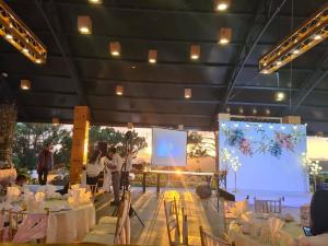 Love Hill Resort في دالات: مرحلة فيها طاولات وكراسي وشاشة عرض +230 صورة