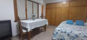 Un dormitorio con una cama y una mesa con un jarrón de flores en Remanso en Bahía Blanca