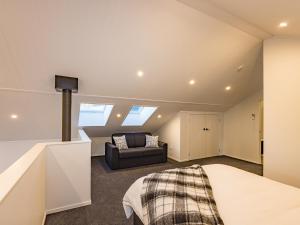 a attic bedroom with a bed and a couch at Mangawhero River Chalet in Ohakune