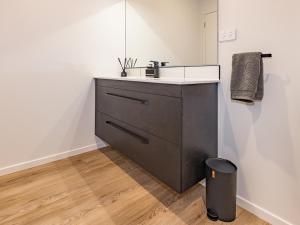 a bathroom with a sink and a trash can at Mangawhero River Chalet in Ohakune +21 photos
