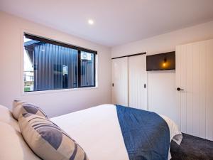 a bedroom with a bed and a window at Mangawhero River Chalet in Ohakune