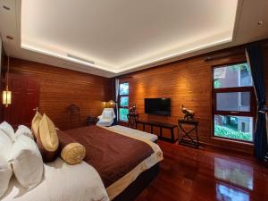 a hotel room with a bed and a television at Prince Manor Resort in Phnom Penh